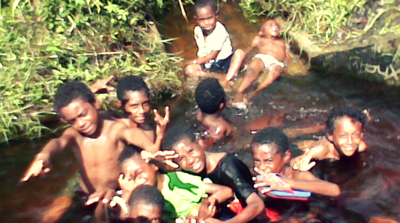 Children playing in one of the flooded swamps along the road